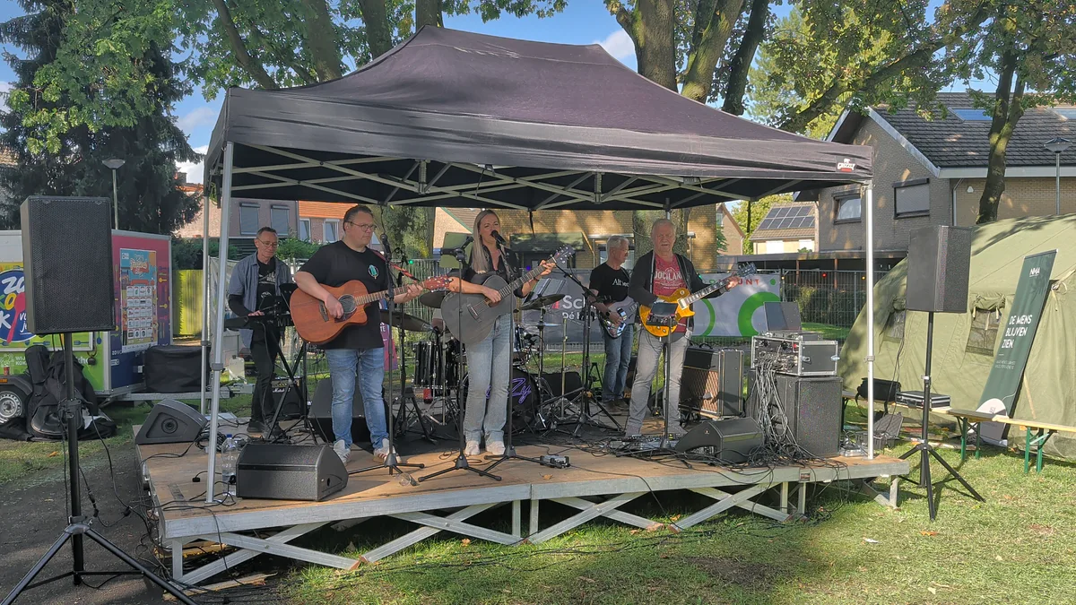 Liveband onder een zwarte overkapping met de luidsprekers, monitors en mengapparatuur van Zaund